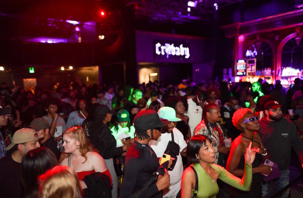 Crowd at club event with purple and green lighting